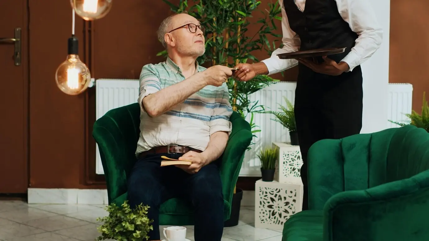 Ein Tourist bezahlt bar für eine Tasse Kaffee.